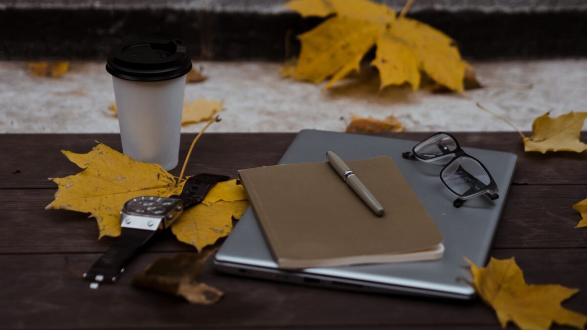 Laptop und Kaffeetasse auf einem Schreibtisch im warmen Licht
