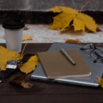 Laptop und Kaffeetasse auf einem Schreibtisch im warmen Licht
