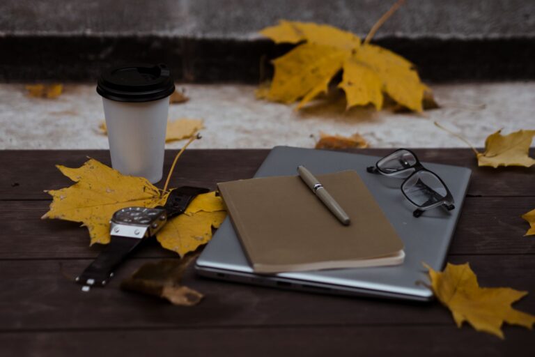 Laptop und Kaffeetasse auf einem Schreibtisch im warmen Licht