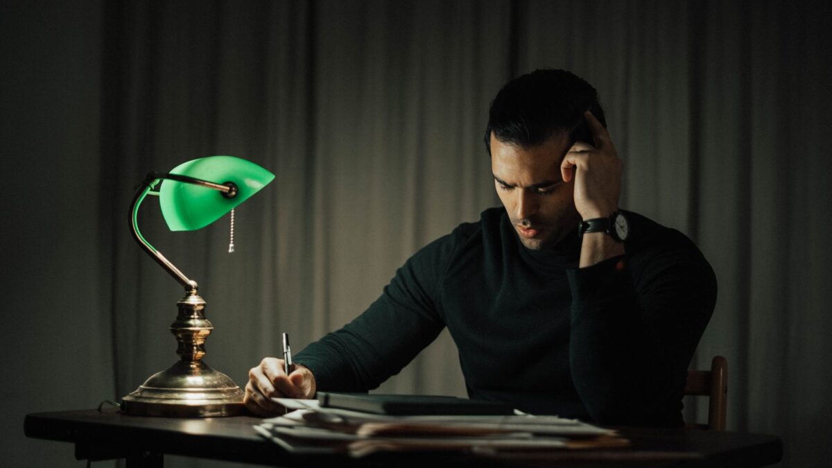 Unterlagen und Notizen im Licht einer Schreibtischlampe