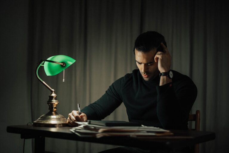 Unterlagen und Notizen im Licht einer Schreibtischlampe