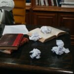 Zerknülltes Papier auf einem Schreibtisch – Überarbeiten und Kürzen von Texten
