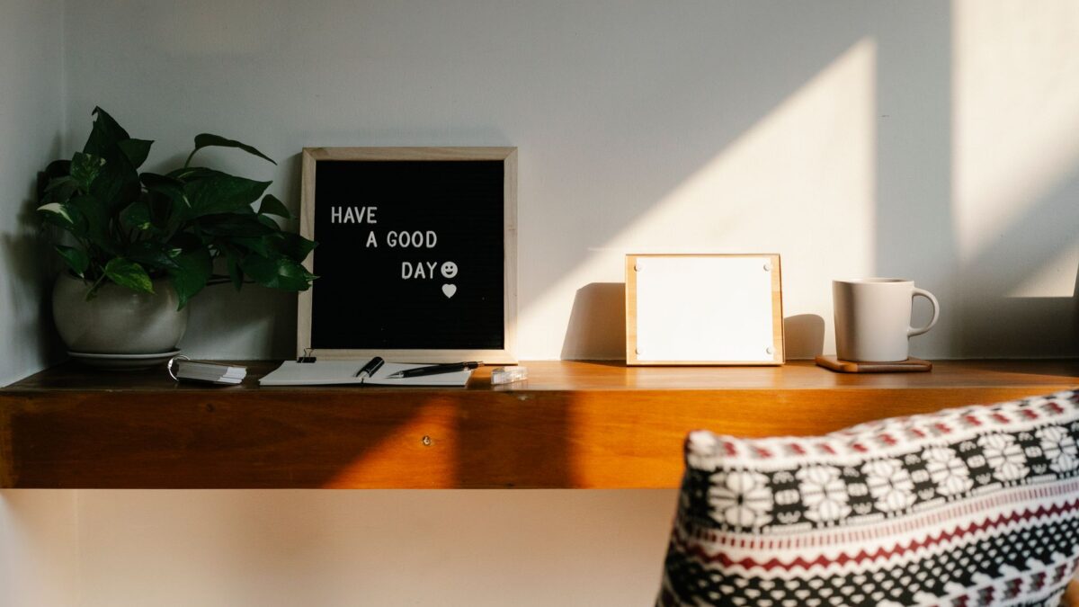 Heller Homeoffice-Arbeitsplatz mit Schreibtisch, Laptop und Pflanze am Fenster