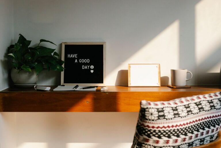 Heller Homeoffice-Arbeitsplatz mit Schreibtisch, Laptop und Pflanze am Fenster