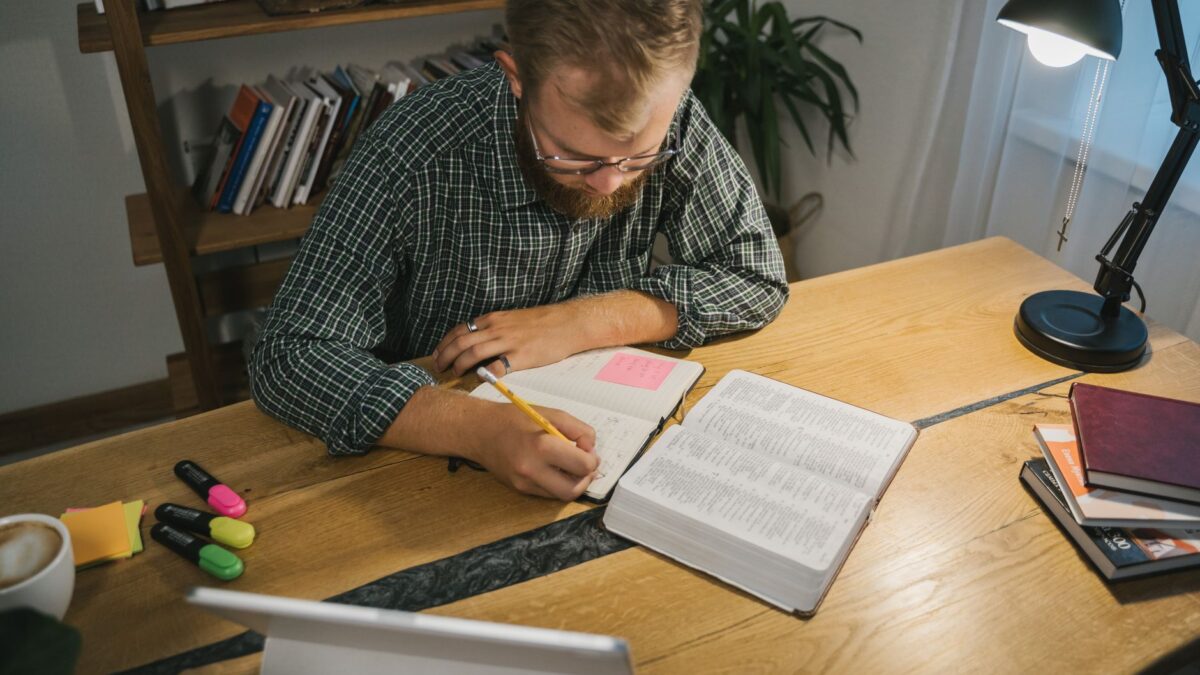Konzentriertes Arbeiten am aufgeräumten Schreibtisch mit Notizbuch und Kaffee