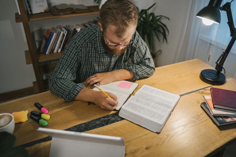 Konzentriertes Arbeiten am aufgeräumten Schreibtisch mit Notizbuch und Kaffee