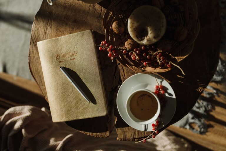 Notizbuch mit Stift und Kaffeetasse im warmen Morgenlicht