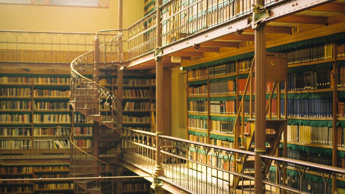 Historischer Bibliothekssaal mit hohen Bücherregalen in warmem Licht